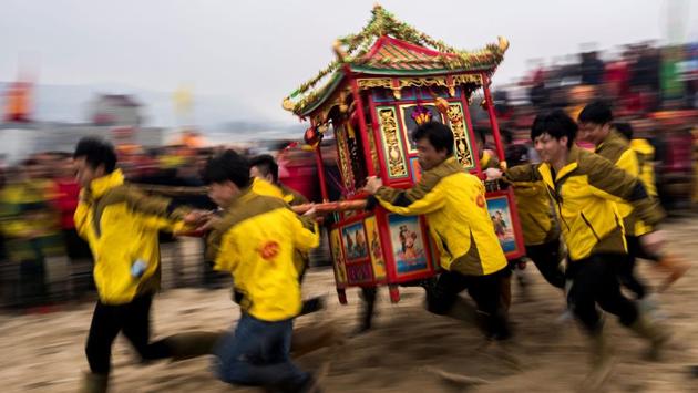 “Possessed” by local gods, elaborately dressed villagers in Fuye, eastern China are carried into the surf to ensure an abundant catch during the “Dash of the Ocean Gods” festival. (Johannes Eisele / AFP) “Possessed” by local gods, elaborately dressed villagers in Fuye, eastern China are carried into the surf to ensure an abundant catch during the “Dash of the Ocean Gods” festival. (Johannes Eisele / AFP)