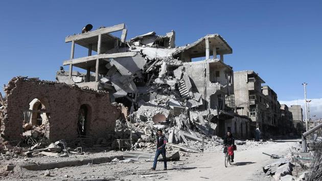 Syrians walk past destroyed buildings in the rebel-held town of Hamouria, in the besieged Eastern Ghouta region on the outskirts of the capital Damascus. (AFP Photo) Syrians walk past destroyed buildings in the rebel-held town of Hamouria, in the besieged Eastern Ghouta region on the outskirts of the capital Damascus. (AFP Photo)