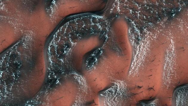 This NASA file handout image obtained on August 24, 2017, shows snow and ice accumulated during Winter covering dunes in the planet's Northern hemisphere. Buried glaciers have been spotted on Mars.(AFP File Photo)