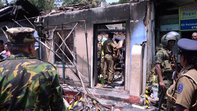 Sri Lanka's Special Task Force and Police officers stand guard near a burnt house after a clash between two communities in Digana, central district of Kandy in Sri Lanka. (Reuters File Photo)