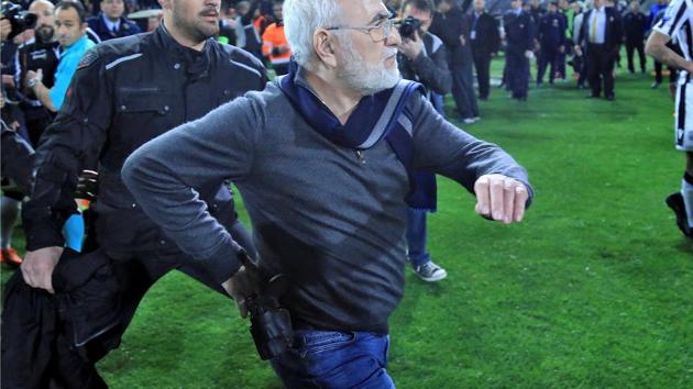 Russian-born Greek businessman and owner of PAOK Salonika, Ivan Savvides (C), pictured with what appears to be a gun in a holster, enters the pitch after the referee annulled a goal of PAOK during their football match against AEK Athens in Toumba Stadium in Thessaloniki, Greece, on Sunday. (REUTERS) Russian-born Greek businessman and owner of PAOK Salonika, Ivan Savvides (C), pictured with what appears to be a gun in a holster, enters the pitch after the referee annulled a goal of PAOK during their football match against AEK Athens in Toumba Stadium in Thessaloniki, Greece, on Sunday. (REUTERS)