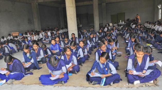 Students taking their exam sitting on the floor in an inn at Government Senior Secondary School, Neechi Mangali in Ludhiana on Monday. (Gurminder Singh/HT) Students taking their exam sitting on the floor in an inn at Government Senior Secondary School, Neechi Mangali in Ludhiana on Monday. (Gurminder Singh/HT)