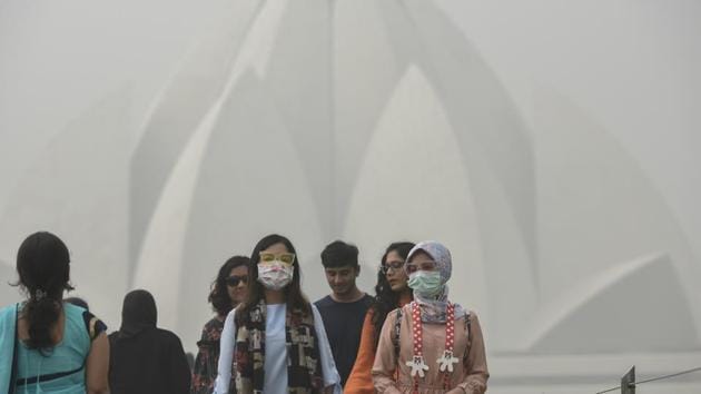 Foreign tourists at the Lotus Temple on a smoggy morning in New Delhi. A Global Burden of Disease report published last year estimated that 1.1 million deaths in India were linked to PM 2.5 air pollution in 2015.(Burhaan Kinu/HT File Photo)