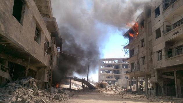 Fire and smoke gush out of buildings following reported air strikes on the Syrian besieged rebel-held town of Daraya near the capital Damascus on August 16, 2016.(AFP File Photo)