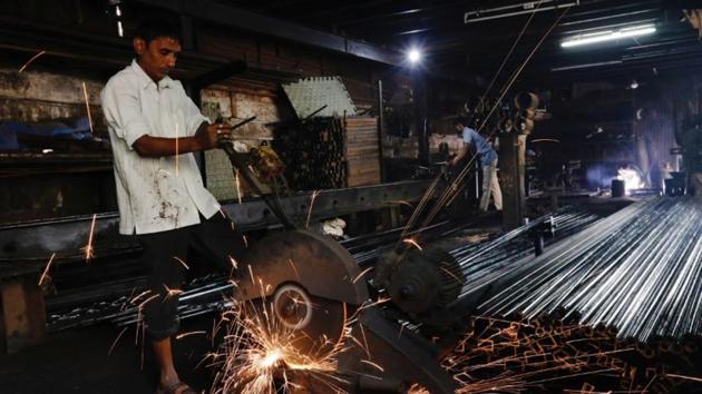 Workers make pipes used for drilling, at a factory in an industrial area in Mumbai, India. (Reuters File)
