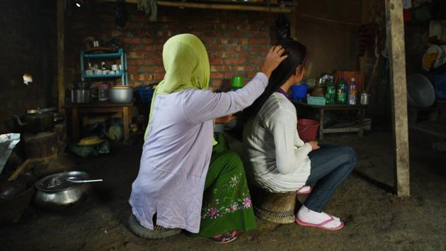 A Manipuri girl who was rescued from Yangon in 2017 at home with her mother. A promise of employment --as a housemaid or babysitter, with food and accommodation, in Singapore, Thailand or China while earning 500 Singapore dollars a month-- is irresistible for both the parents and girls. The network usually involves three sets of agents – one in India, the other in Myanmar and the last in the destination country. (Vipin Kumar / HT Photo) 