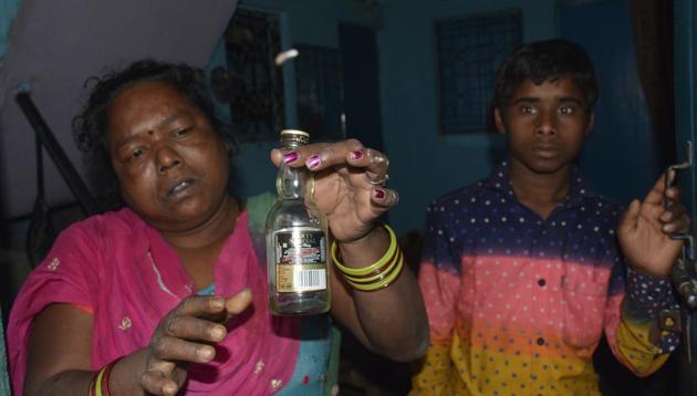 A Khoda resident holds up a smuggled liquor bottle. Four persons of the colony died after consuming spurious liquor on Monday. (Sakib Ali /HT Photo) A Khoda resident holds up a smuggled liquor bottle. Four persons of the colony died after consuming spurious liquor on Monday. (Sakib Ali /HT Photo)