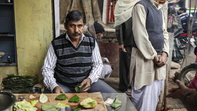 A betel leaf vendor poses for a photograph at his stall near Assi Ghat in Varanasi, Uttar Pradesh. A senior adviser at the labour ministry said last week it was decided to count jobs growth in establishment having less than 10 employees.(Dhiraj Singh/Bloomberg)