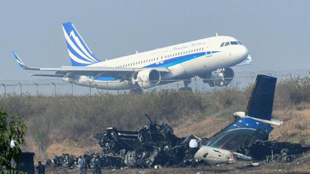 An airplane takes off at the international airport in Kathmandu on Tuesday near the wreckage of a US-Bangla Airlines plane that crashed on Monday. (AFP) An airplane takes off at the international airport in Kathmandu on Tuesday near the wreckage of a US-Bangla Airlines plane that crashed on Monday. (AFP)