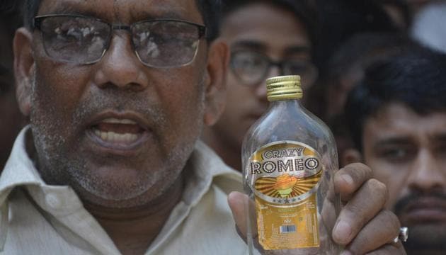 A Khoda resident holds up an empty liquor bottle of an inferior brand that is sold in the area. Officials suspect that empty bottles are refilled with adulterated liquor and then sold to people. (Sakib Ali/Ht Photo) A Khoda resident holds up an empty liquor bottle of an inferior brand that is sold in the area. Officials suspect that empty bottles are refilled with adulterated liquor and then sold to people. (Sakib Ali/Ht Photo)