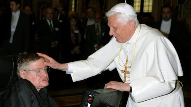 Pope Benedict XVI (R) greets British professor Stephen Hawking during a meeting of science academics on October 31, 2008 at the Vatican. Hawking said belief in a God who intervenes in the universe “to make sure the good guys win or get rewarded in the next life” was wishful thinking. “But one can’t help asking the question: Why does the universe exist?” he said in 1991. (Osservatore Romano / REUTERS File)