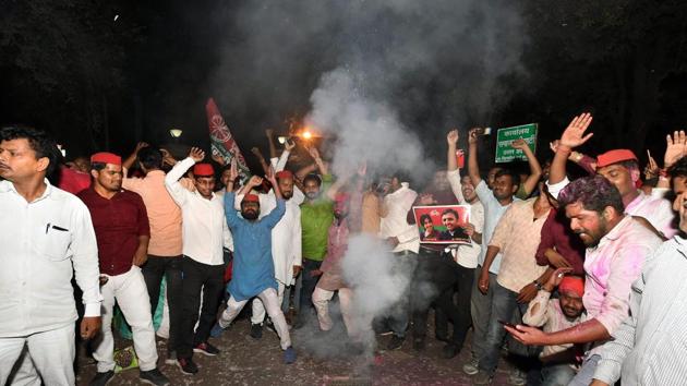 Samajwadi Party supporters celebrate the win in Phulpur and Gorakhpur bypolls, in front of the party office in Lucknow on Wednesday.(PTI Photo)