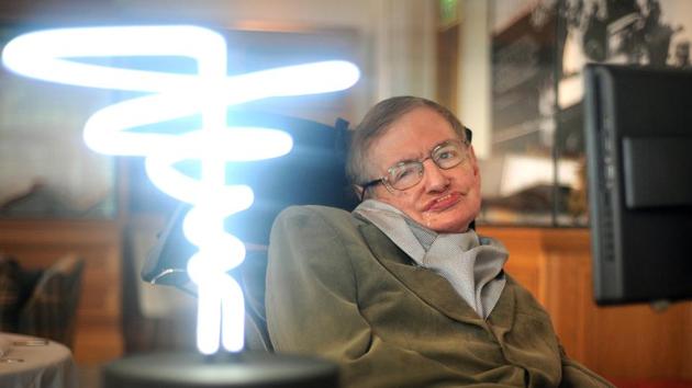 In this Feb. 25, 2012 photo, Professor Stephen Hawking poses beside a lamp titled 'black hole light' by inventor Mark Champkins, presented to him during his visit to the Science Museum in London.(AP)