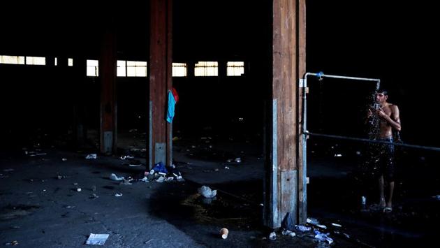 A few hundred, mostly young Afghan or Pakistani men, are squatted in abandoned factories facing the port and shower in water that runs yellow in pipes rusty from disuse. (Alkis Konstantinidis / REUTERS) A few hundred, mostly young Afghan or Pakistani men, are squatted in abandoned factories facing the port and shower in water that runs yellow in pipes rusty from disuse. (Alkis Konstantinidis / REUTERS)
