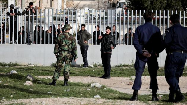 A migrant (3-R) speaks with a port police officer, as others climb the metal fence at the port of Patras. When borders closed in March 2016 and a European Union deal with Turkey stranded over 50,000 refugees and migrants in Greece, Patras started buzzing again, said Dimitris Kyriakoulopoulos, a coast guard captain overlooking the port. (Alkis Konstantinidis / REUTERS) A migrant (3-R) speaks with a port police officer, as others climb the metal fence at the port of Patras. When borders closed in March 2016 and a European Union deal with Turkey stranded over 50,000 refugees and migrants in Greece, Patras started buzzing again, said Dimitris Kyriakoulopoulos, a coast guard captain overlooking the port. (Alkis Konstantinidis / REUTERS)