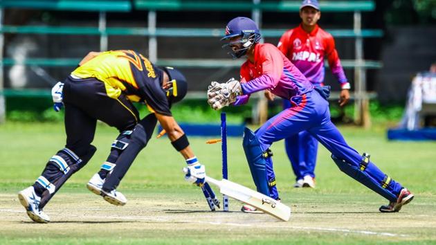 Nepal wicket keeper attempts a run out of PNG batsman Chad Soper. (ICC)