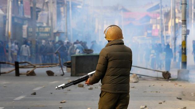 A policeman takes position against stone pelters during clashes which erupted after the funeral prayers of a student turned militant who was killed along with top other commanders in Anantnag encounter, at Soura in Srinagar on Monday.(PTI File photo)