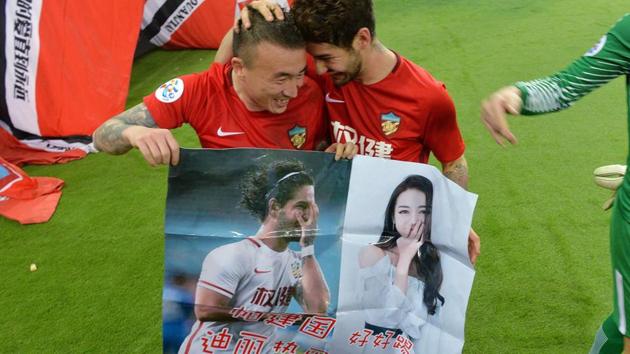 Alexandre Pato of Tianjin Quanjian (R), holding a poster showing pictures of him and Chinese actress Dilraba Dilmurat, with teammate Wang Yongpo. (AFP) Alexandre Pato of Tianjin Quanjian (R), holding a poster showing pictures of him and Chinese actress Dilraba Dilmurat, with teammate Wang Yongpo. (AFP)