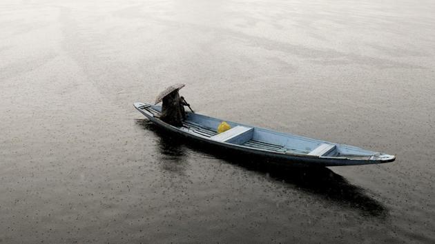 A Kashmiri boatman rows his boat at Dal Lake during rainfall in Srinagar on Thursday. (Waseem Andrabi / HT Photo) A Kashmiri boatman rows his boat at Dal Lake during rainfall in Srinagar on Thursday. (Waseem Andrabi / HT Photo)