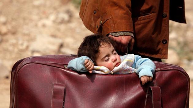 A sleeping child is carried in a bag in the village of Beit Sawa, eastern Ghouta, Syria. (Omar Sanadiki / REUTERS) A sleeping child is carried in a bag in the village of Beit Sawa, eastern Ghouta, Syria. (Omar Sanadiki / REUTERS)