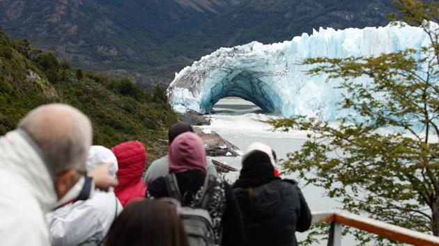 Tourists etake snapshots at the Perito Moreno Glacier, at Los Glaciares National Park, near El Calafate in the Argentine province of Santa Cruz. An arch of ice formed at the tip of the Perito Moreno, between the glacier and the shore of Argentino lake, started collapsing into the water, a display that happens just once every several years. (Walter Diaz / AFP) Tourists etake snapshots at the Perito Moreno Glacier, at Los Glaciares National Park, near El Calafate in the Argentine province of Santa Cruz. An arch of ice formed at the tip of the Perito Moreno, between the glacier and the shore of Argentino lake, started collapsing into the water, a display that happens just once every several years. (Walter Diaz / AFP)