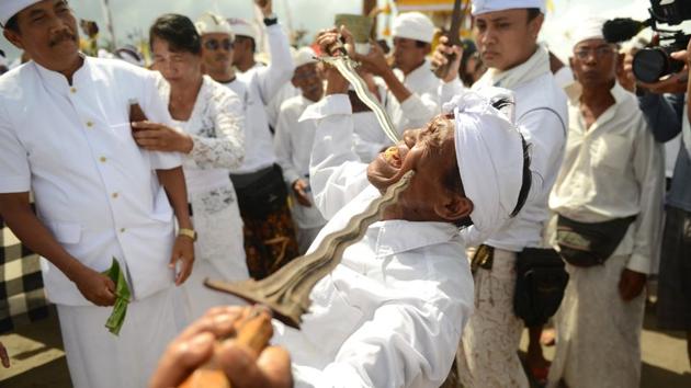 A Balinese man in a trance holds daggers to his cheeks during a Melasti ceremony prayer at Petitenget beach on Indonesia's resort island of Bali. (Sonny Tumbelaka / AFP) A Balinese man in a trance holds daggers to his cheeks during a Melasti ceremony prayer at Petitenget beach on Indonesia's resort island of Bali. (Sonny Tumbelaka / AFP)