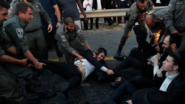 Israeli police remove Ultra-Orthodox Jewish demonstrators who are blocking a road during a protest against Israeli army conscription in the town of Bnei Brak, near Tel Aviv. (Ahmad Gharabli / AFP) Israeli police remove Ultra-Orthodox Jewish demonstrators who are blocking a road during a protest against Israeli army conscription in the town of Bnei Brak, near Tel Aviv. (Ahmad Gharabli / AFP)