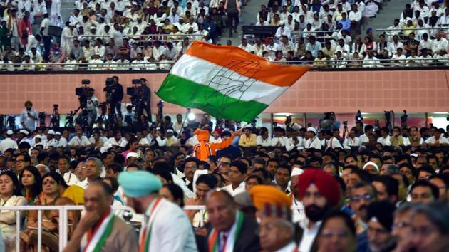 A Congress worker waves a flag during the 84th Plenary Session of Indian National Congress (INC) at the Indira Gandhi Stadium in New Delhi on Saturday.(PTI) A Congress worker waves a flag during the 84th Plenary Session of Indian National Congress (INC) at the Indira Gandhi Stadium in New Delhi on Saturday.(PTI)