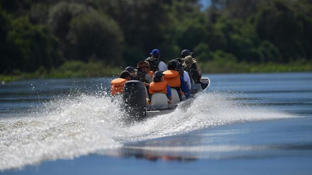 A group of tourists on a boat visit the Pantanal wetlands in Brazil. On the Pantanal, life is governed by the coming and going of dry and rainy seasons. At peak flooding, the Pantanal is a spectacular place for fishing and adventurous tourists. (Carl De Souza / AFP)