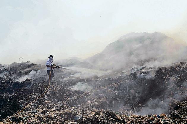 A fireman douses the fire at Ambernath dumping ground on Saturday. (Rishikesh Choudhary/HT) A fireman douses the fire at Ambernath dumping ground on Saturday. (Rishikesh Choudhary/HT)
