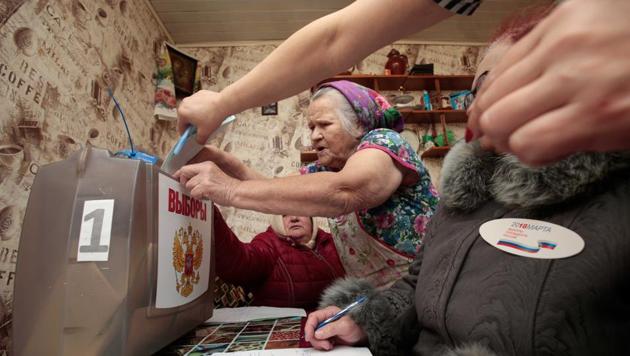 A local casts her vote into a mobile ballot box as members of an election commission sit nearby during the presidential election in a settlement in Smolensk Region, Russia, on Sunday. (Reuters Photo) A local casts her vote into a mobile ballot box as members of an election commission sit nearby during the presidential election in a settlement in Smolensk Region, Russia, on Sunday. (Reuters Photo)