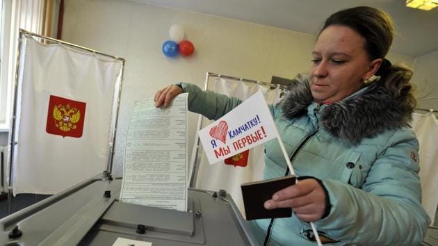 A woman holds a flag that reads "I love Kamchatka, we are the first!" as she prepares to cast her ballots at a polling station in Yelizovo, about 30 kilometers ( 19 miles) north-east from Petropavlovsk-Kamchatsky in Russia. (AP Photo) A woman holds a flag that reads "I love Kamchatka, we are the first!" as she prepares to cast her ballots at a polling station in Yelizovo, about 30 kilometers ( 19 miles) north-east from Petropavlovsk-Kamchatsky in Russia. (AP Photo)
