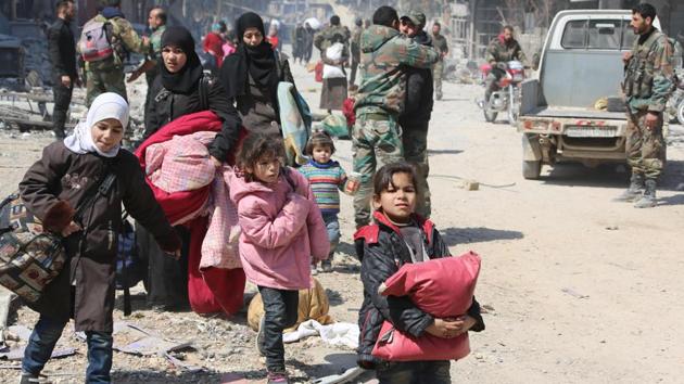 Syrian women and children walk past government soldiers as they evacuate from the town of Jisreen in the southern Eastern Ghouta, on the eastern outskirts of the capital Damascus, on March 17, 2018. (AFP Photo) Syrian women and children walk past government soldiers as they evacuate from the town of Jisreen in the southern Eastern Ghouta, on the eastern outskirts of the capital Damascus, on March 17, 2018. (AFP Photo)