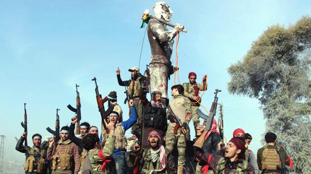 Turkey-backed Free Syrian Army soldiers celebrate around a statue of Kawa, a mythology figure in Kurdish culture as they prepare to destroy it in Afrin’s city center. The Syrian Observatory for Human Rights war monitor has reported looting, saying Turkey’s Syrian allies “have begun pillaging private property, political and military sites and shops.” (Hasan Kırmızitaş / AP) Turkey-backed Free Syrian Army soldiers celebrate around a statue of Kawa, a mythology figure in Kurdish culture as they prepare to destroy it in Afrin’s city center. The Syrian Observatory for Human Rights war monitor has reported looting, saying Turkey’s Syrian allies “have begun pillaging private property, political and military sites and shops.” (Hasan Kırmızitaş / AP)