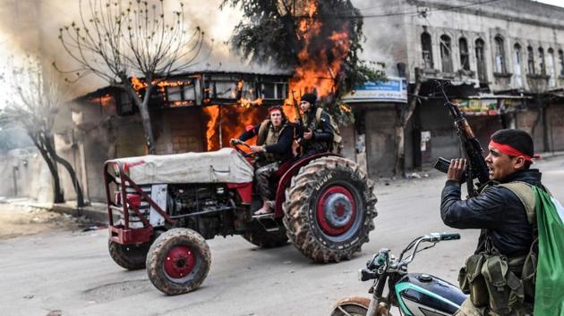 A Turkish-backed Syrian rebel drives past a burning shop in Afrin. Turkey’s seizure of the town in northern Syria is a significant military achievement for President Recep Tayyip Erdogan that gives him control over a large chunk of Syrian territory but also entrenches his troops as an occupying force in a crowded terrain packed with adversaries. (Bulent Kilic / AFP) A Turkish-backed Syrian rebel drives past a burning shop in Afrin. Turkey’s seizure of the town in northern Syria is a significant military achievement for President Recep Tayyip Erdogan that gives him control over a large chunk of Syrian territory but also entrenches his troops as an occupying force in a crowded terrain packed with adversaries. (Bulent Kilic / AFP)