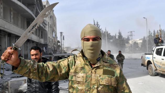 A Turkish-backed Syrian rebel raises a dagger in Afrin. After seizing control, Erdogan said Turkey would also target a region stretching nearly 400 km east of the northern Syrian town of Qamishli. However, expansion of the campaign into the much larger Kurdish-held territory east also risks confronting US troops, deployed alongside a YPG-dominated force in northern Syria. (Bulent Kilic / AFP) A Turkish-backed Syrian rebel raises a dagger in Afrin. After seizing control, Erdogan said Turkey would also target a region stretching nearly 400 km east of the northern Syrian town of Qamishli. However, expansion of the campaign into the much larger Kurdish-held territory east also risks confronting US troops, deployed alongside a YPG-dominated force in northern Syria. (Bulent Kilic / AFP)
