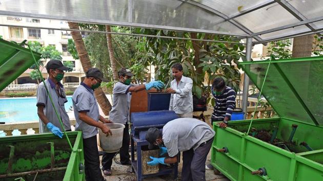 Workers process waste at a composting centre at the Valley of Flowers society in Kandivli. (Satyabrata Tripathy/HT)