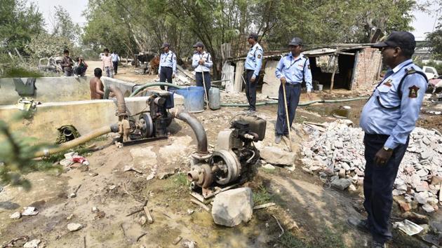 Guards on patrol assess a site on the floodplain where tube wells are being used. Thousands of gallons of groundwater are being extracted daily with the help of submersible pumps from the Yamuna floodplains — one of the few groundwater recharging zones left in Delhi — and supplied through tankers to commercial establishments in the city. (Sanchit Khanna / HT Photo) Guards on patrol assess a site on the floodplain where tube wells are being used. Thousands of gallons of groundwater are being extracted daily with the help of submersible pumps from the Yamuna floodplains — one of the few groundwater recharging zones left in Delhi — and supplied through tankers to commercial establishments in the city. (Sanchit Khanna / HT Photo)