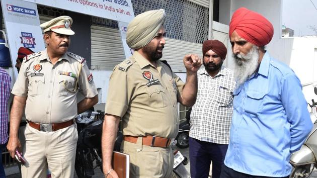 Police officials investigating after armed robbers loot ₹18 lakh from collection agency employees outside a bank on Ferozepur Road in Ludhiana on Tuesday. (Gurminder Singh/HT) Police officials investigating after armed robbers loot ₹18 lakh from collection agency employees outside a bank on Ferozepur Road in Ludhiana on Tuesday. (Gurminder Singh/HT)
