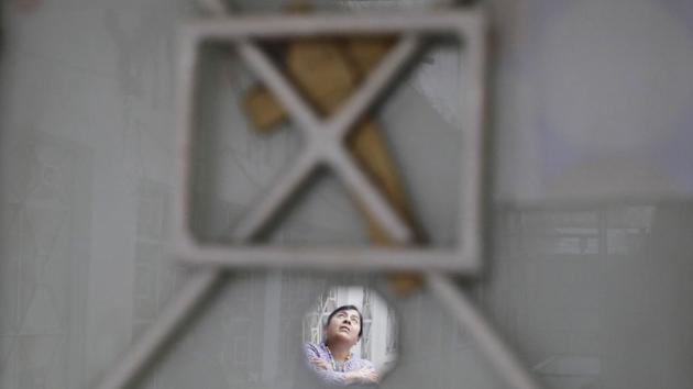 Luz Maria Alvarez Lopez, is reflected in a mirror which adorns her apartment’s front door, in a damaged building at Independencia 18 in Mexico City where her family occupied four homes. Mexico City Reconstruction Commissioner Edgar Oswaldo Tungui Rodriguez said there are 27 such camps around the capital, but denied people were living in them. Rather, he said, quake victims had just posted guards to watch over property. (Rebecca Blackwell / AP)