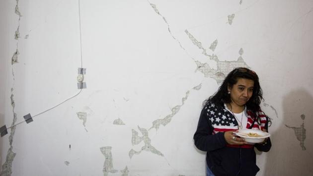 A woman eats a meal provided by volunteers inside a damaged building in southern Mexico City. Six months after the quake, some families with nowhere else to go have moved back in to their apartments in damaged buildings, as they continue to wait for a verdict on whether the structures can be repaired and how long that process might take. (Rebecca Blackwell / AP)