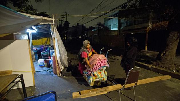 Maria Patricia Rodriguez Gonzalez packs up her wares, at the tent camp where she has been living all these months. Before the quake, she sold soda and candy out of a shop in the ground-floor apartment where she lived. “It makes us sad that people insult us without knowing the reality we are living,” she said. “We’re not here because we want to be. We’re here out of necessity.” (Rebecca Blackwell / AP)