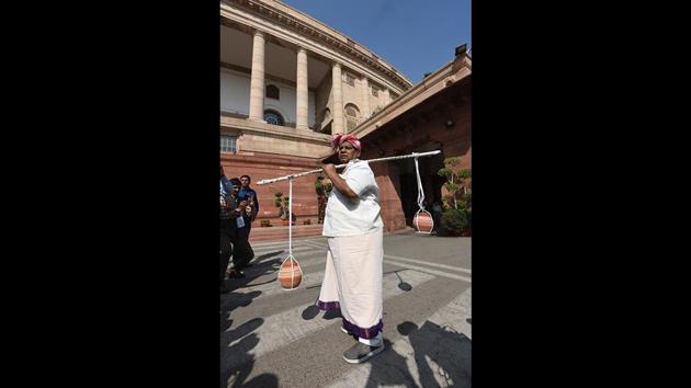 In a farmer’s attire, Sivaprasad carried water and mud in earthen pots tied to a wooden twig as a part of his party’s protest against the Centre for not granting Special Category status to Andhra Pradesh, during the second phase of budget session in New Delhi on March 07. (Sonu Mehta / HT Photo) 