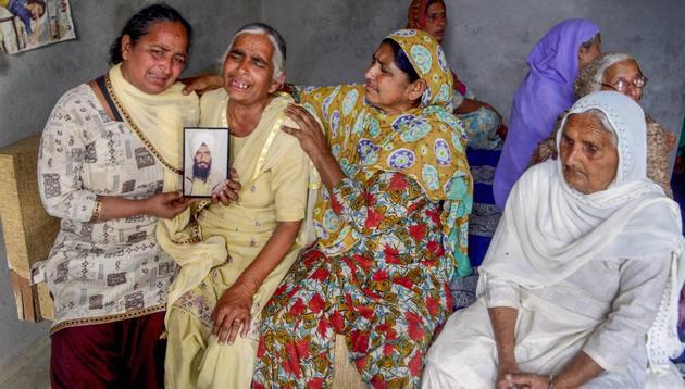 Family members of one of the 39 Indian workers killed in Iraq mourn holding his portrait, on the outskirts of Amritsar on Tuesday. (PTI) Family members of one of the 39 Indian workers killed in Iraq mourn holding his portrait, on the outskirts of Amritsar on Tuesday. (PTI)