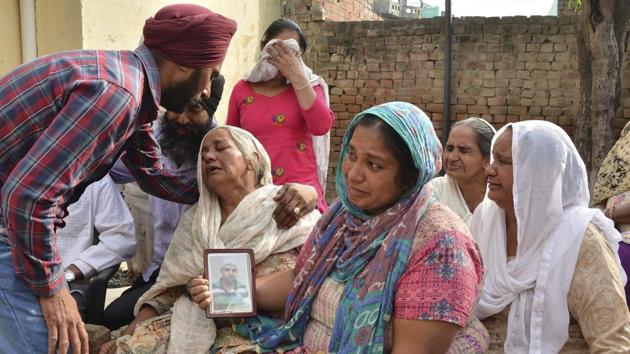 Family members grieve by a portrait of Harsimran Singh, one of the 39 Indian workers whose bodies were found buried northwest of Mosul, in Babowal village of Punjab on Tuesday.(PTI)