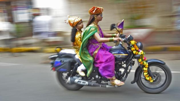 A woman rides a bike with her son during the ‘Gudi Padwa’ celebrations at Girgaon in Mumbai on Sunday. (Ragul Krishnan / HT Photo) A woman rides a bike with her son during the ‘Gudi Padwa’ celebrations at Girgaon in Mumbai on Sunday. (Ragul Krishnan / HT Photo)
