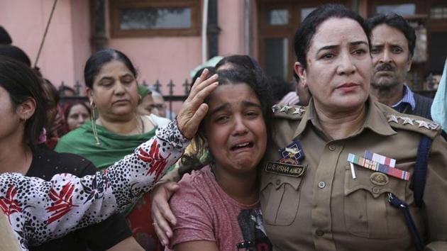 A police officer consoles the daughter of selection grade constable Deepak Thesoo, who was killed in a gunbattle with militants, during his funeral on the outskirts of Jammu on Thursday.(AP Photo)
