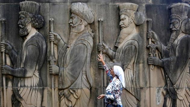 A woman touches the wall of a Parsi fire temple featuring huge carvings of ancient priests on the occasion of the Persian New Year in Mumbai on Wednesday. (Francis Mascarenhas / REUTERS) A woman touches the wall of a Parsi fire temple featuring huge carvings of ancient priests on the occasion of the Persian New Year in Mumbai on Wednesday. (Francis Mascarenhas / REUTERS)