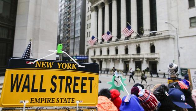 A wall Street plate is seen while pedestrians pass in front of the New York Stock Exchange (NYSE) on March 1 in New York City. (AFP file) A wall Street plate is seen while pedestrians pass in front of the New York Stock Exchange (NYSE) on March 1 in New York City. (AFP file)