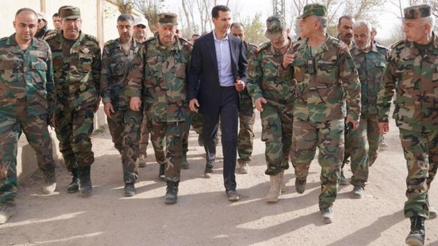 Syrian President Bashar al-Assad walks with Syrian army soldiers in eastern Ghouta, Syria In the leader’s first trip to the former rebel enclave outside Damascus in years, on March 18, 2018. (SANA / Handout via REUTERS) Syrian President Bashar al-Assad walks with Syrian army soldiers in eastern Ghouta, Syria In the leader’s first trip to the former rebel enclave outside Damascus in years, on March 18, 2018. (SANA / Handout via REUTERS)